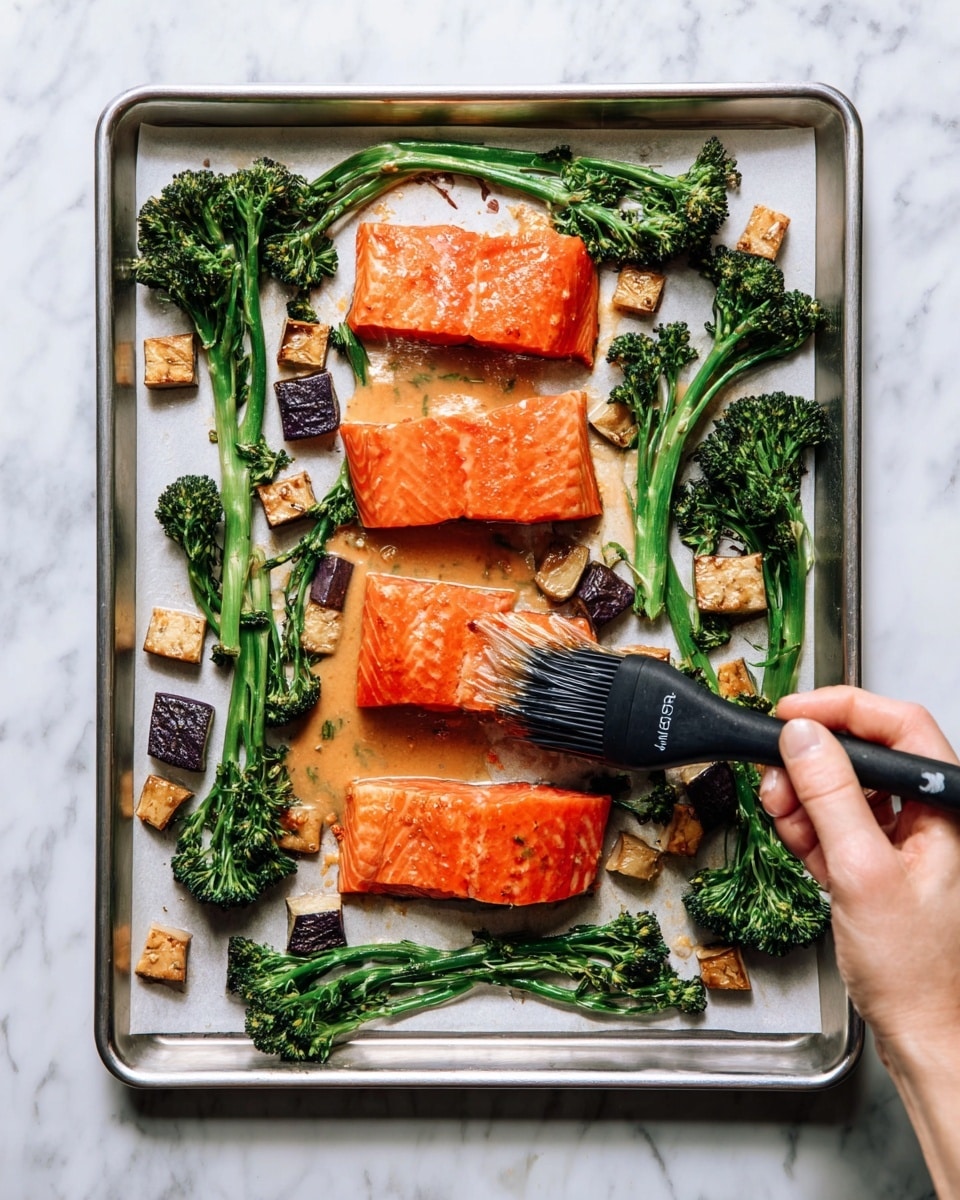 The image shows a dish on a white plate with three main layers: a grilled salmon fillet in the center with a smooth, bright orange color; to the left, small cubes of roasted eggplant with dark purple skin and golden brown roasted sides; and to the right, a bunch of broccolini with dark green florets and lightly charred stems. The salmon is topped with pieces of chopped green onion scattered across the fillet and around the plate. A vintage silver fork rests on the right side of the plate, near the broccolini, all placed on a white marbled surface. Photo taken with an iphone --ar 4:5 --v 7