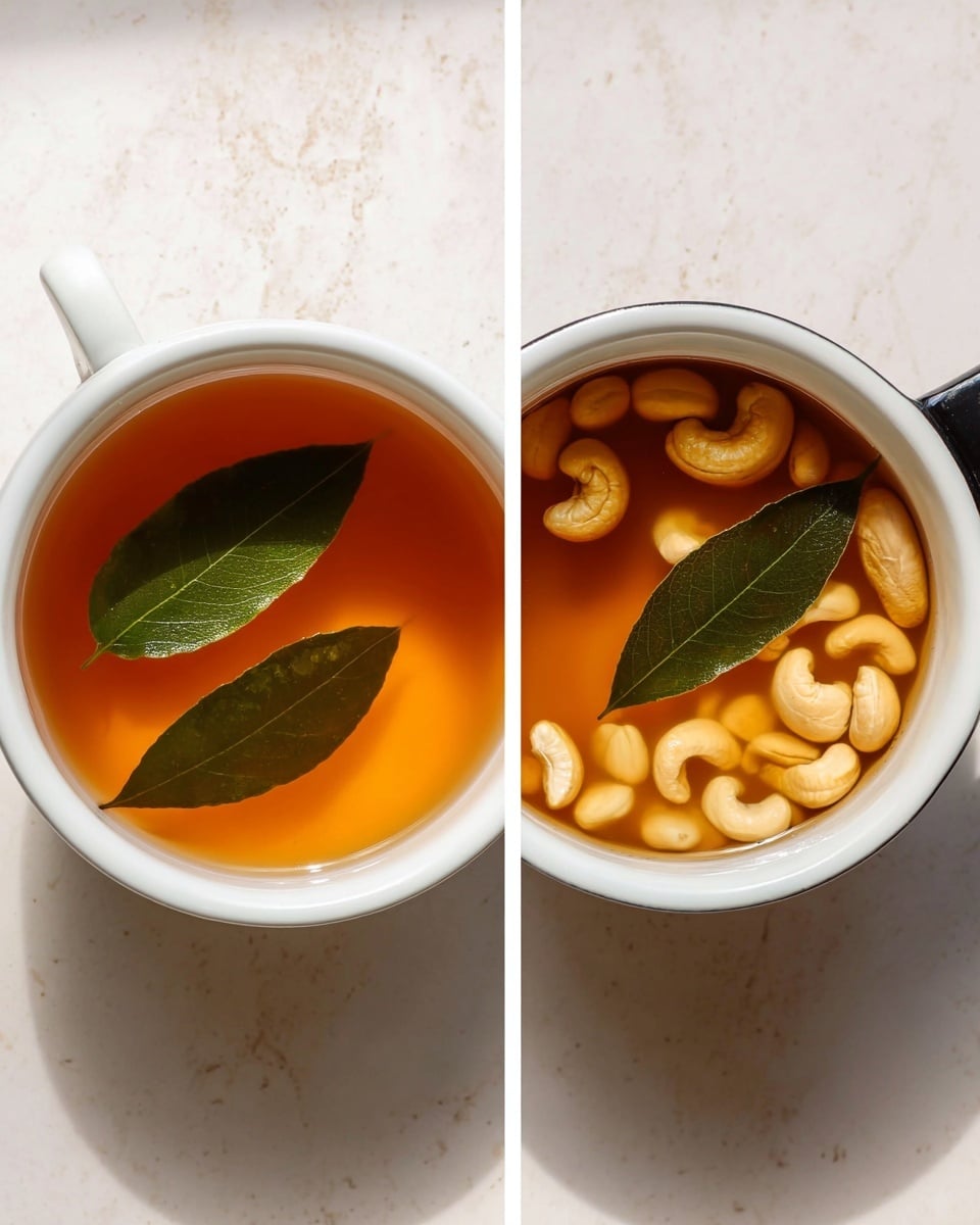 The image shows two white pots placed side by side on a white marbled surface. The left pot is filled with a clear, amber-colored liquid with two green bay leaves floating on top. The right pot contains the same amber liquid, but with many small, pale cashew nuts floating in it along with two green bay leaves placed in the center. Both pots have black handles visible on the right side. The lighting is soft and natural, enhancing the warm colors of the liquid and the smooth texture of the cashews. photo taken with an iphone --ar 4:5 --v 7