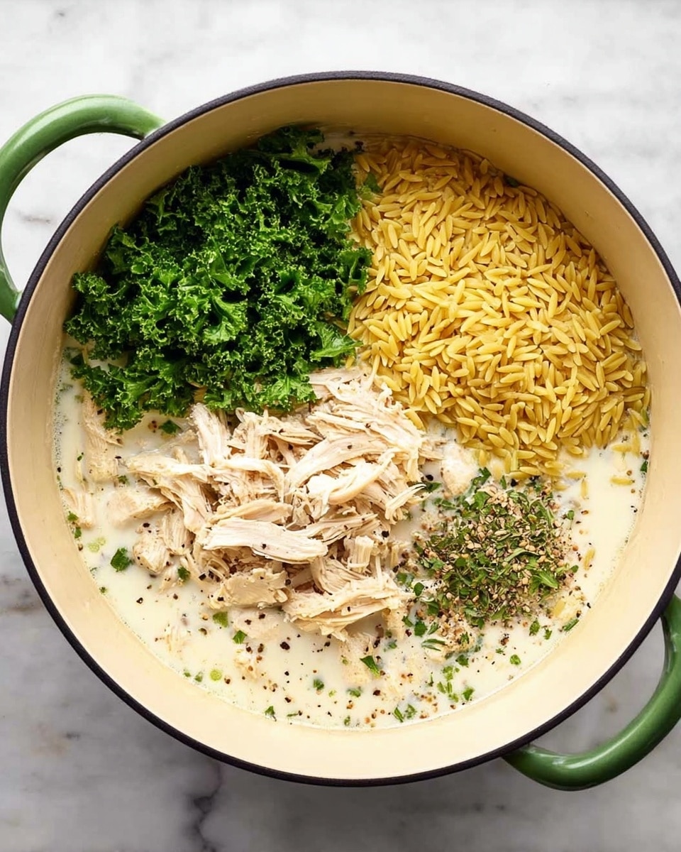 The dish is a creamy pasta served on a white scalloped plate placed on a white marbled surface. The pasta is mixed with green herbs and small pieces of white chicken, creating a light yellow and green speckled look. On top, there is a layer of finely shredded white cheese sprinkled with freshly ground black pepper. A silver fork and spoon with wooden handles rest on the right side of the plate. A few green herb leaves are scattered on top for garnish, and a white cloth with gray stripes is softly draped in the background. photo taken with an iphone --ar 4:5 --v 7