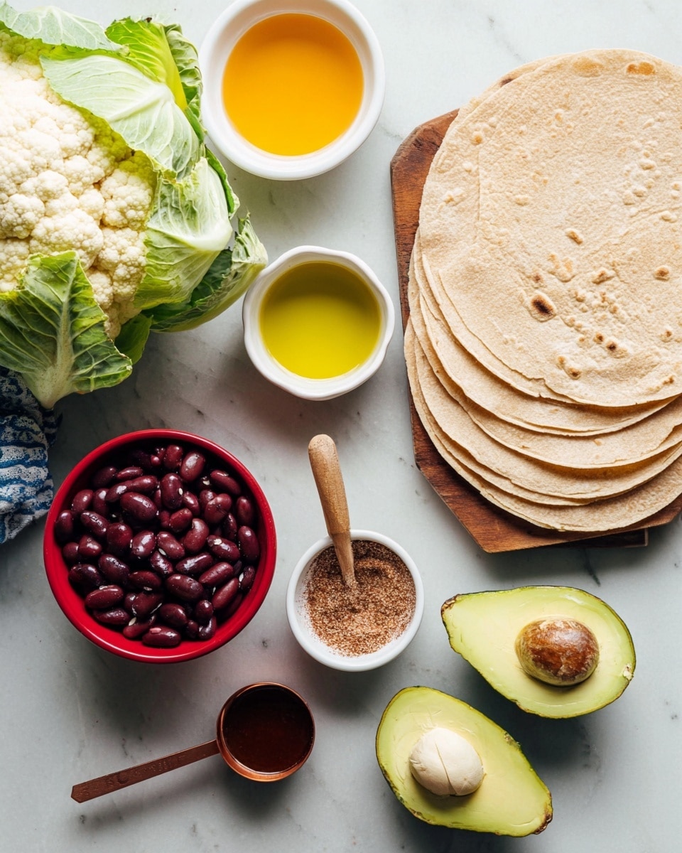 A collection of fresh and raw ingredients is arranged on a white marbled surface. At the top right, five light brown soft tortillas overlap each other. Below, two avocado halves show light green smooth flesh, one with a brown seed and the other empty. To the far left, a whole cauliflower with white bumpy texture and green leaves sits next to a small white bowl filled with yellow oil. Above it, a red bowl holds dark red kidney beans with a shiny surface. In the middle, a small white bowl filled with fine brown spices has a small wooden spoon standing inside it. Next to it, a copper measuring spoon with a dark liquid rests on the white marbled surface. In the top left corner, part of a white bowl with bright orange sauce is visible. photo taken with an iphone --ar 4:5 --v 7